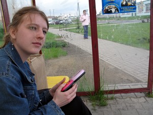 Emiliana czeka w jedynej budce na rondzie w Jerce na autobus o 16.20 do Śremu. Wraca z uczelni w Lesznie. Nudzi się i gra. Jest godz. 15.41.