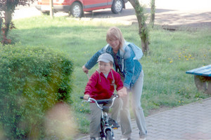 74. Fot. Johann Bączkiewicz. Kościan, osiedle Konstytucji 3 Maja. Zdjęcie przedstawia mamę uczącą dziecko jazdy na rowerze.