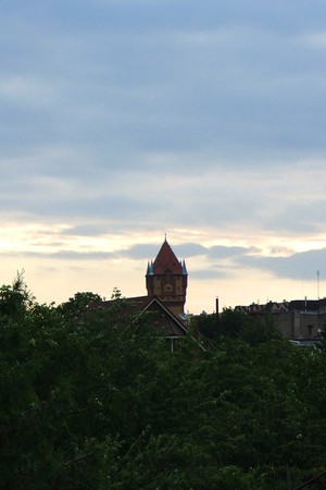 Autor - Andrzej Prałat. Godzina 6:41. Zdjęcie przedstawia kościańską wieże ciśnień widzianą ze strony południowo-zachodniej poprzez prywatne ogródki.