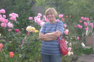 Autor: Piotr Borowiak. Zdjęcie przedstawia moją mamę w alei różanej przy ośrodku szkoleniowym w Gierłachowie.