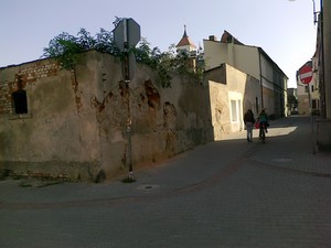 Stanisław Walkowiak - zdjęcie przedstawia urokliwy zakątek w centrum miasta Kościana. Na fotografii zabytkowy zapewne budynek. Na uwagę zasługuje  mur z nadgryzionej dosłownie czasem czerwonej cegły. Zdjęcie wykonano podczas porannego spaceru po mieście.